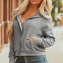 Grå våffelskarvs-skarvsjacka med dragkedja framtill med knapp på huva